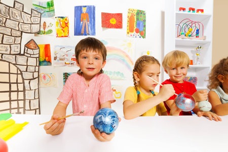Smiling kids paint New Year balls for Xmas treeの写真素材