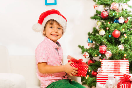 Little boy with present under New year treeの写真素材