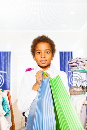 African boy wears white shirt with bags in storeの写真素材