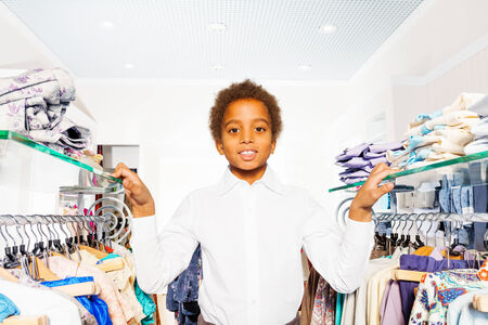 African boy in white shirt stand between hangersの写真素材