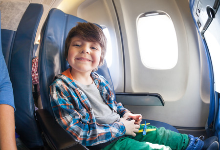 Portrait of little boy in airplane seat by windowの写真素材