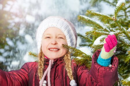 Portrait of happy girl with fir tree and snowの写真素材