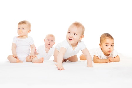 Four cute babies crawl in a row wear white bodyの写真素材