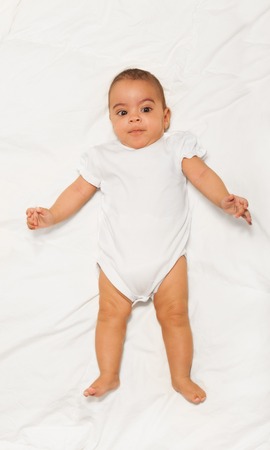 Chubby African small baby wearing white babygroの写真素材