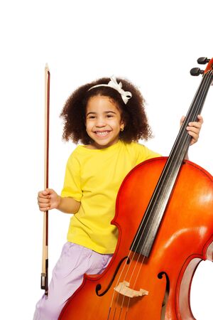 Cheerful African girl holds cello with fiddlestickの写真素材