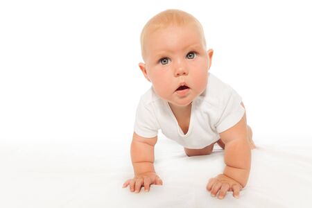Curious looking baby crawls wearing white bodysuitの写真素材