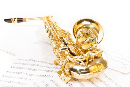 Alto saxophone laying on the musical notesの写真素材