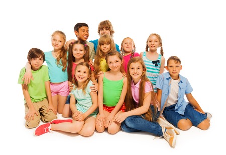 Group portrait of large group of preteens sitting isolated on whiteの写真素材