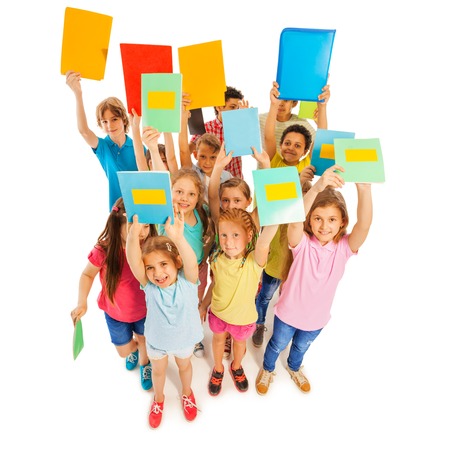 Group portrait of cool and confident 8 years old students lifting textbooks isolated on whiteの写真素材