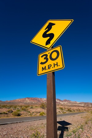 Close-up of arrow yellow road sign in desert, California, United Statesの写真素材