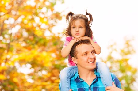 Father with little daughter sits on shouldersの写真素材