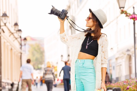 Girl wearing sunglasses shooting with camera touristic attractions on the street during summer day timeの写真素材