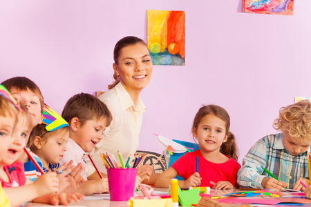 Early developing class boys and girls with teacher make handmade crafts and happy teacher smilingの写真素材