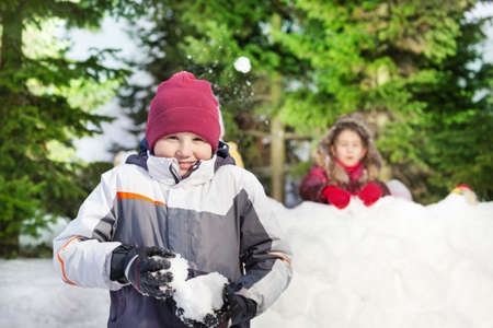 Two happy friends boy and girl playing at the snowballsの写真素材