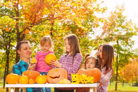 Whole family with three kids and parents prepare for Halloween part sitting in the autumn gardenの写真素材