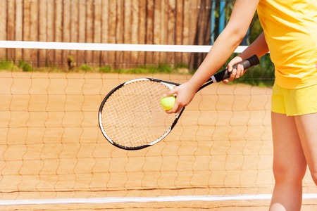 Picture of female player with tennis ball and racket preparing to serve on the clay courtの写真素材