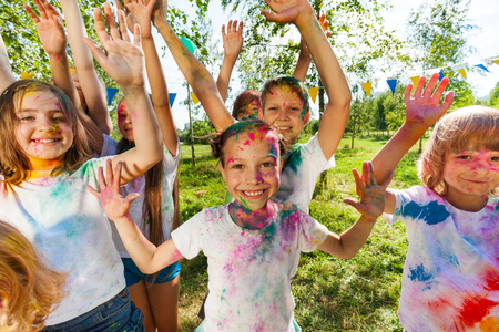 Portrait of bright kids smeared in colored powder at the outdoor color festival in summerの写真素材