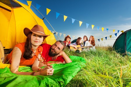 Portrait of happy young couple in tent enjoying camp trip in summerの写真素材