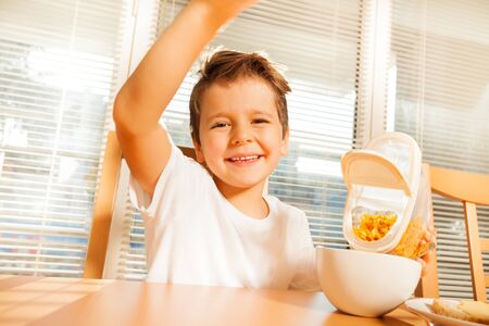 Happy boy making breakfast in the kitchen
