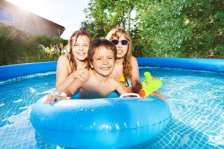 Happy kids swimming in the pool with rubber ringの写真素材