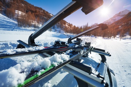 Opened car roof rails with two pairs of skis against beautiful natureの写真素材