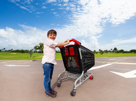 Little helper pushing supermarket shopping cartの写真素材
