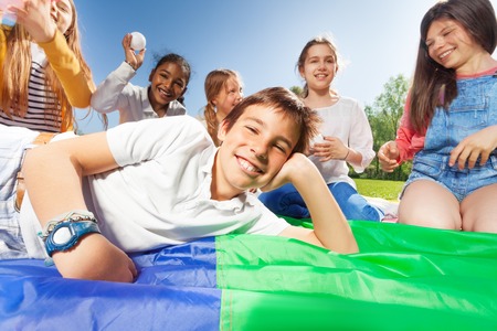 Happy boy laying on colorful mat in the parkの写真素材