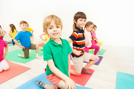Happy kids practicing gymnastics on mats in gymの写真素材