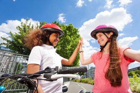 Happy bike riders giving high five after racingの写真素材