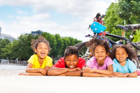 Happy children resting after cycling outdoorsの写真素材