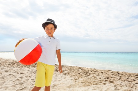Adorable little kid in hat with beach ballの写真素材