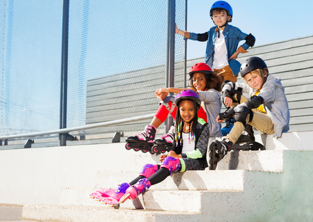 Kids in roller skates sitting on steps of stadium