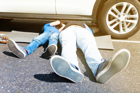 Father teaching son doing car maintenance workの写真素材