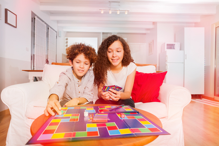 Boy and girl playing tabletop game at homeの写真素材