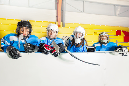 School hockey team sitting on the bench near arenaの写真素材