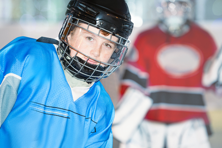 Junior hockey player in blue uniform and helmetの写真素材