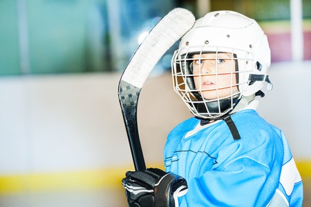 Little hockey player in helmet and blue uniformの写真素材