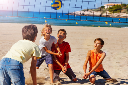 Young volleyball players in action on sandy beachの写真素材