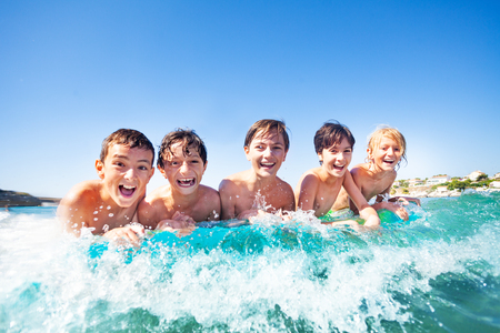 Five happy friends swimming on air mattressの写真素材