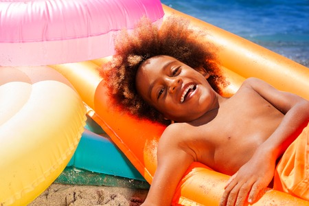 Happy African boy enjoying summer at the seaside