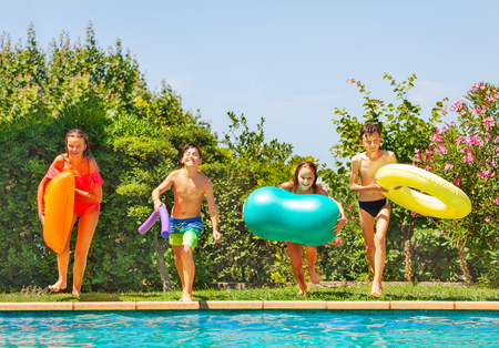 Kids preparing to jump into water of swimming poolの写真素材