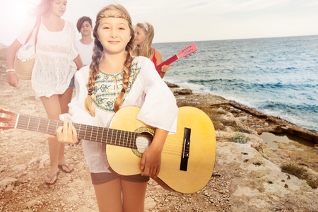 Girl playing guitar for her friends on the beachの写真素材