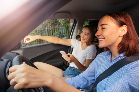 Girl pointing right way to mother during road tripの写真素材