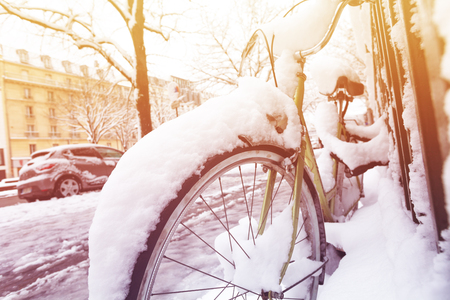 Bike under snow parked along the street in Parisの写真素材