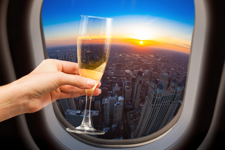 Glass of wine and Chicago view from plane windowの写真素材
