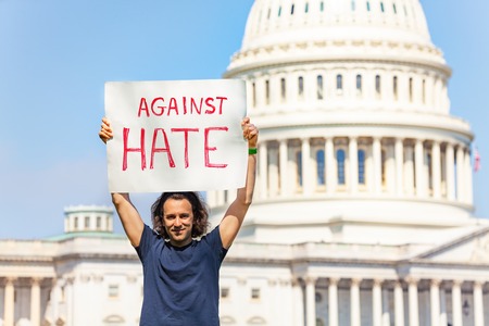 Protester holding sign against hate in his handsの写真素材
