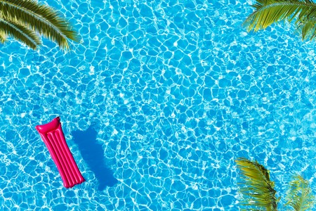 Vacation pool with matrass surface and palm trees