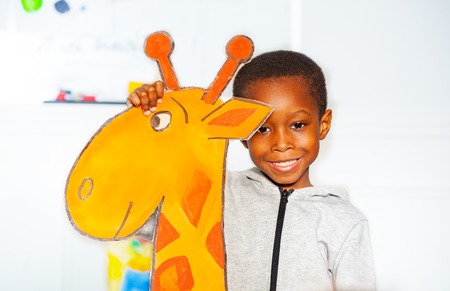 Portrait of black smiling little boy with giraffeの写真素材