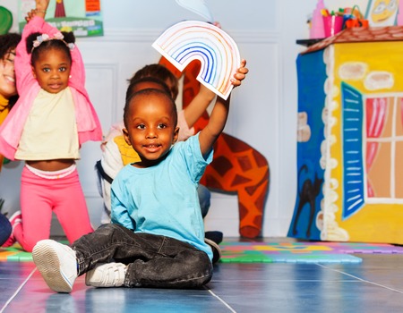 Little black girl show rainbow card in classの写真素材