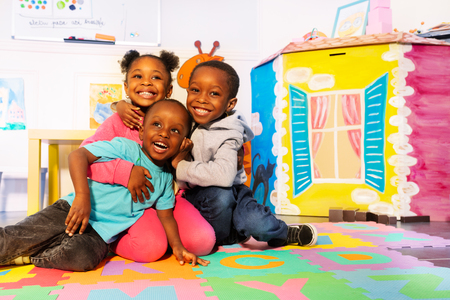 Laughing group of kids play on the floor in roomの写真素材